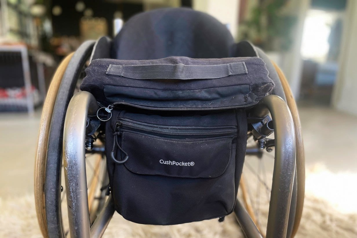 A picture of a CushPocket—a patented fabric storage bag that attaches to wheelchairs.