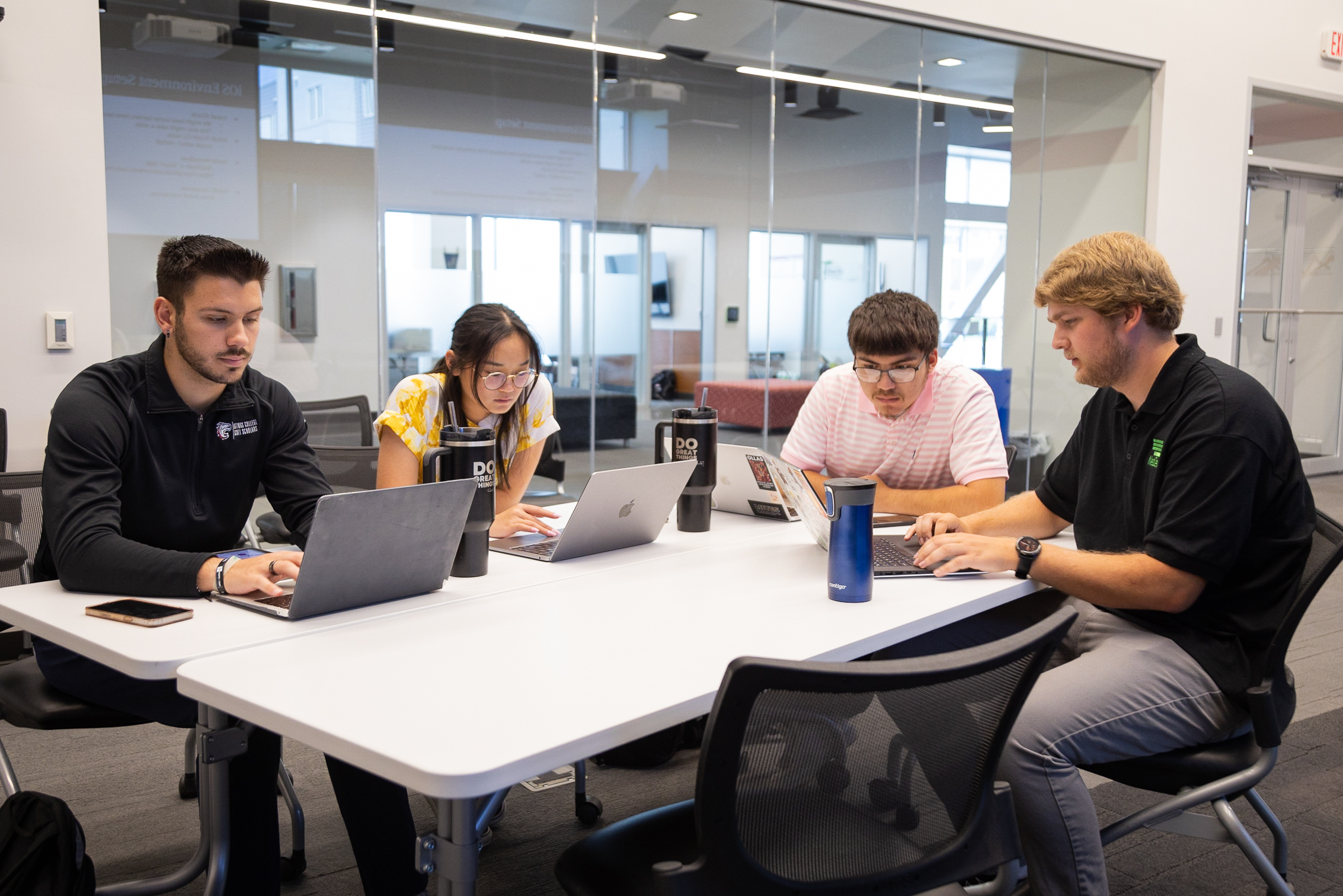Group of Neb Dev staffers sit at a conference room table with their laptops