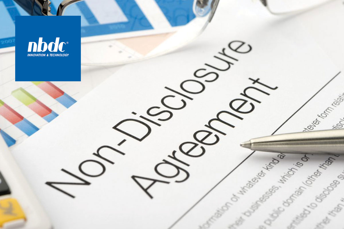 Document with "Non-Disclosure Agreement" at the top with a pen, glasses and caculator
