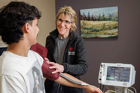 a health care worker takes the blood pressure of a patient.