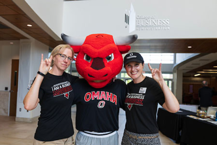 two women stand with durango, uno's mascot