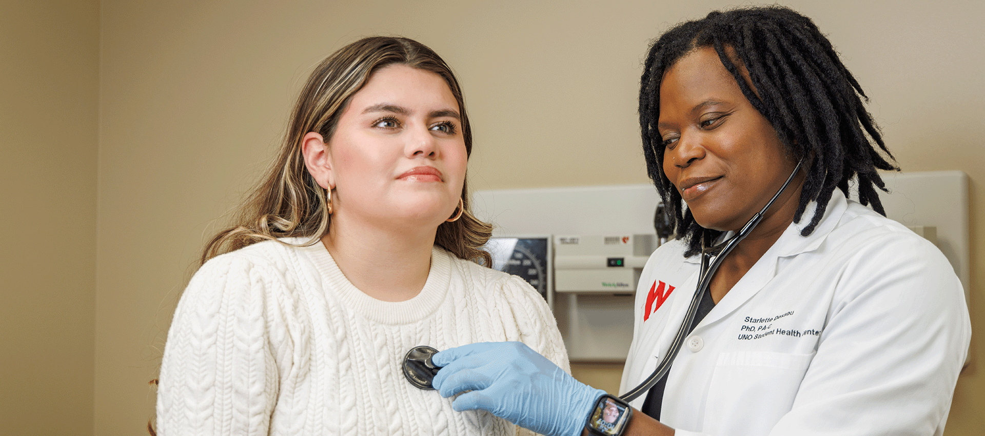 a doctor uses a stethoscope on a patient.