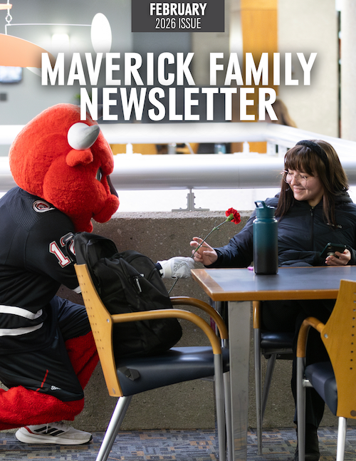 UNO's mascot Durango hands a student a flower.