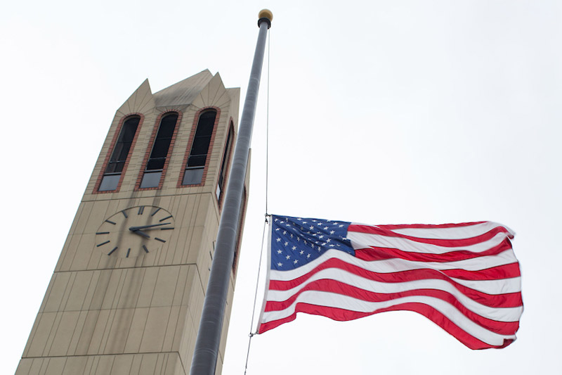 A lowered American flag by the Henningson Memorial Campanile