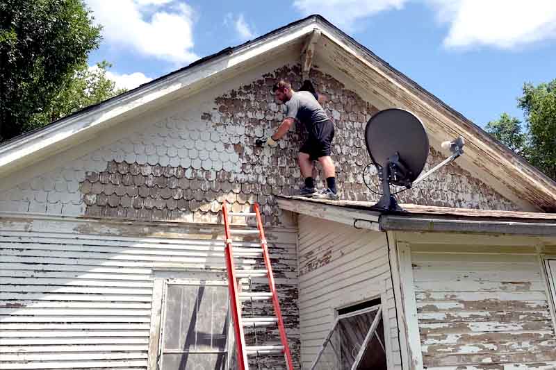 Trevor Harlow works on refurbishing a house in Columbus
