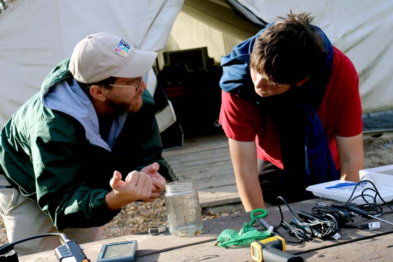 A Northwest High School student and member of the Omaha Henry Doorly Zoo and Aquarium look over a water bug captured from Pawnee Creek