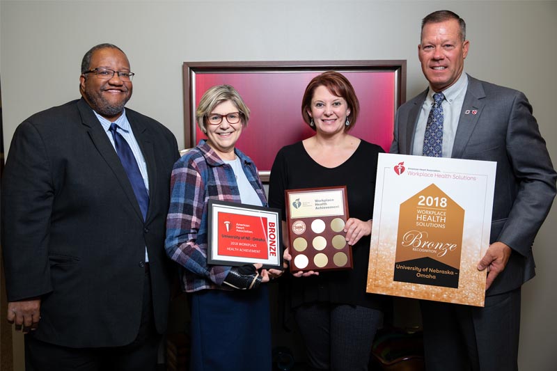 The American Heart Association presents UNO representatives with the Workplace Health Achievement Bronze Award for 2018