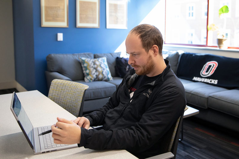 A student in the OMVS office does research on his laptop