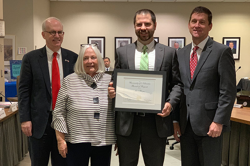 Joe Hayes receives his award next to (left to right) Chancellor Jeffrey P. Gold, Barbara Weitz and President Hank Bounds