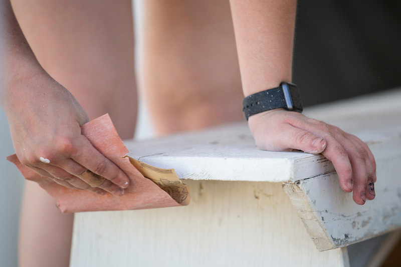 Spartz sanding down a bench