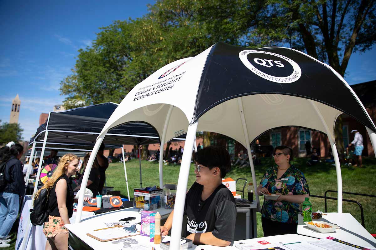 A student stands in the Gender and Sexuality Resource Center booth