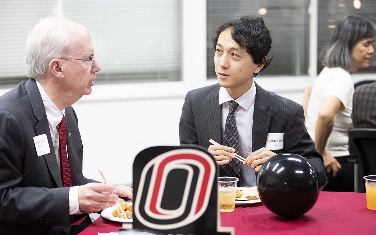 Chancellor Gold speaks with an alumnus at a UNO alumni event held in Tokyo