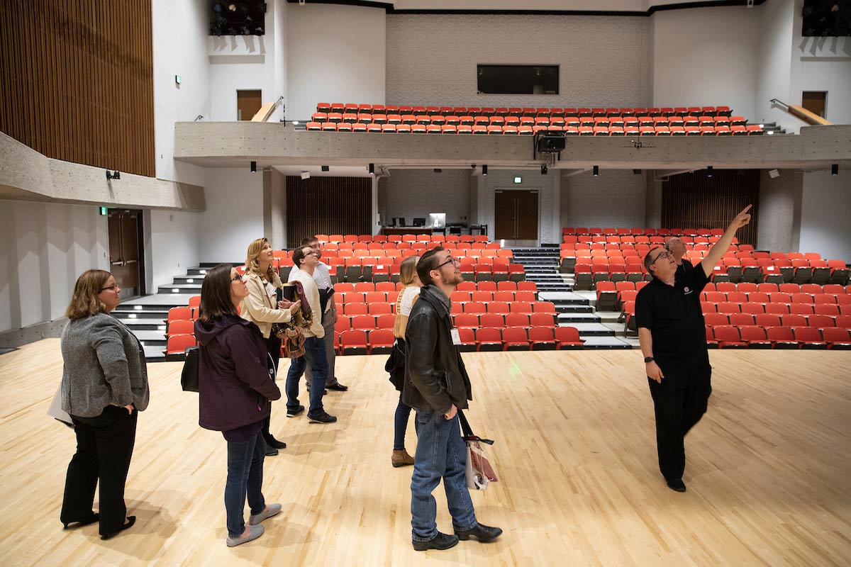 Legislative staff looks around inside the Strauss Performing Arts Center Concert Hall