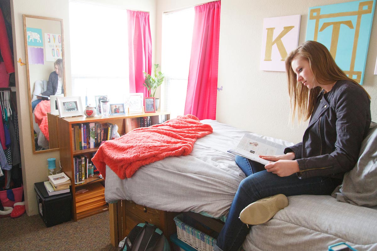 A student studies inside her dorm room