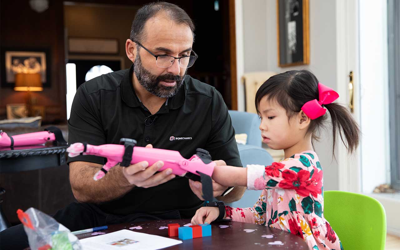 With the guidance of Jorge Zuniga, Ph.D., Rue Gillespie, 4, uses a prosthetic arm 3D-printed at UNO to complete exercises that require precise movements.