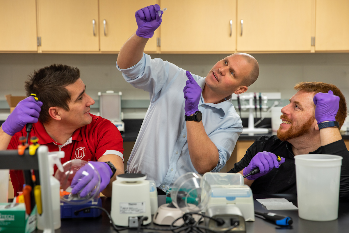 Dustin Slivka, center, works with Christopher Collins, left, and Mark McGlynn in the Health & Kinesiology Building's exercise lab