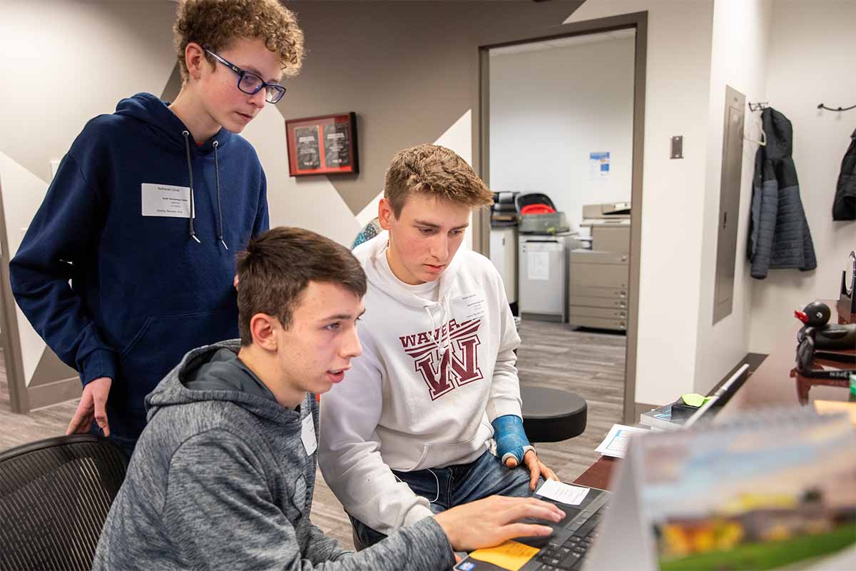 Students use context clues to figure out someone's password in a social engineering challenge. Photos, cards, miscellaneous items and documents left on a desk can provide clues as to what might be someone's password.