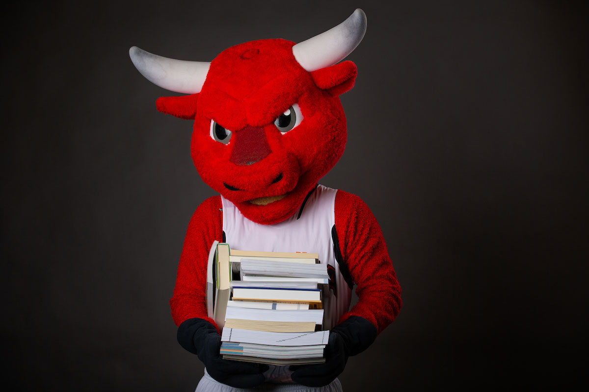 Durango holding a stack of books