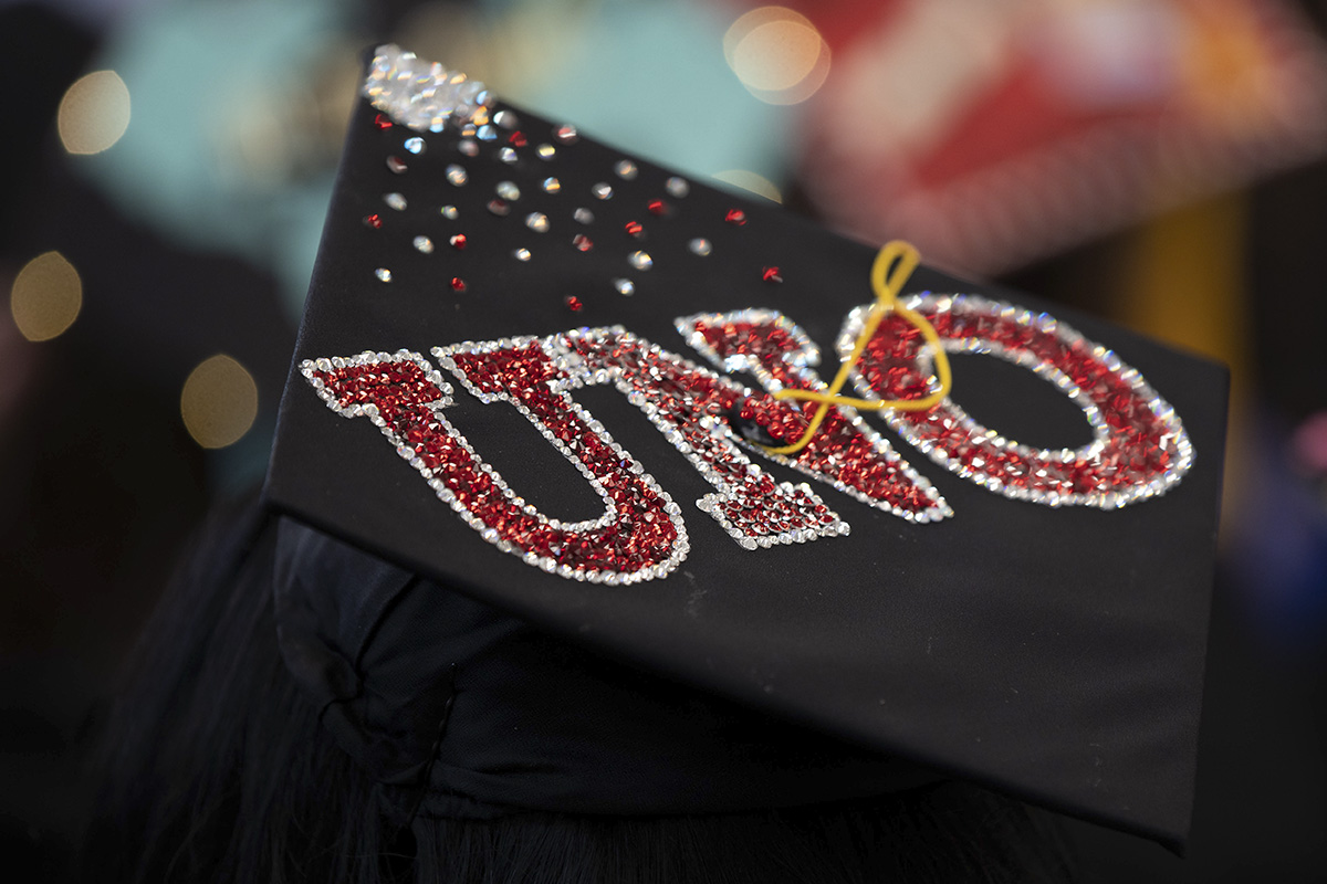 A graduation cap w/ "UNO" written on top in glitter.