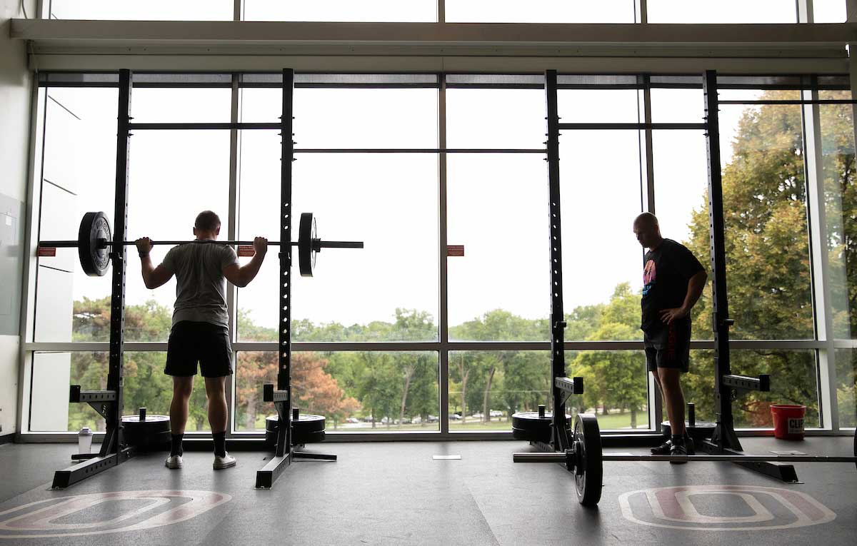 Two students lift weights at the UNO Campus Recreation Center.