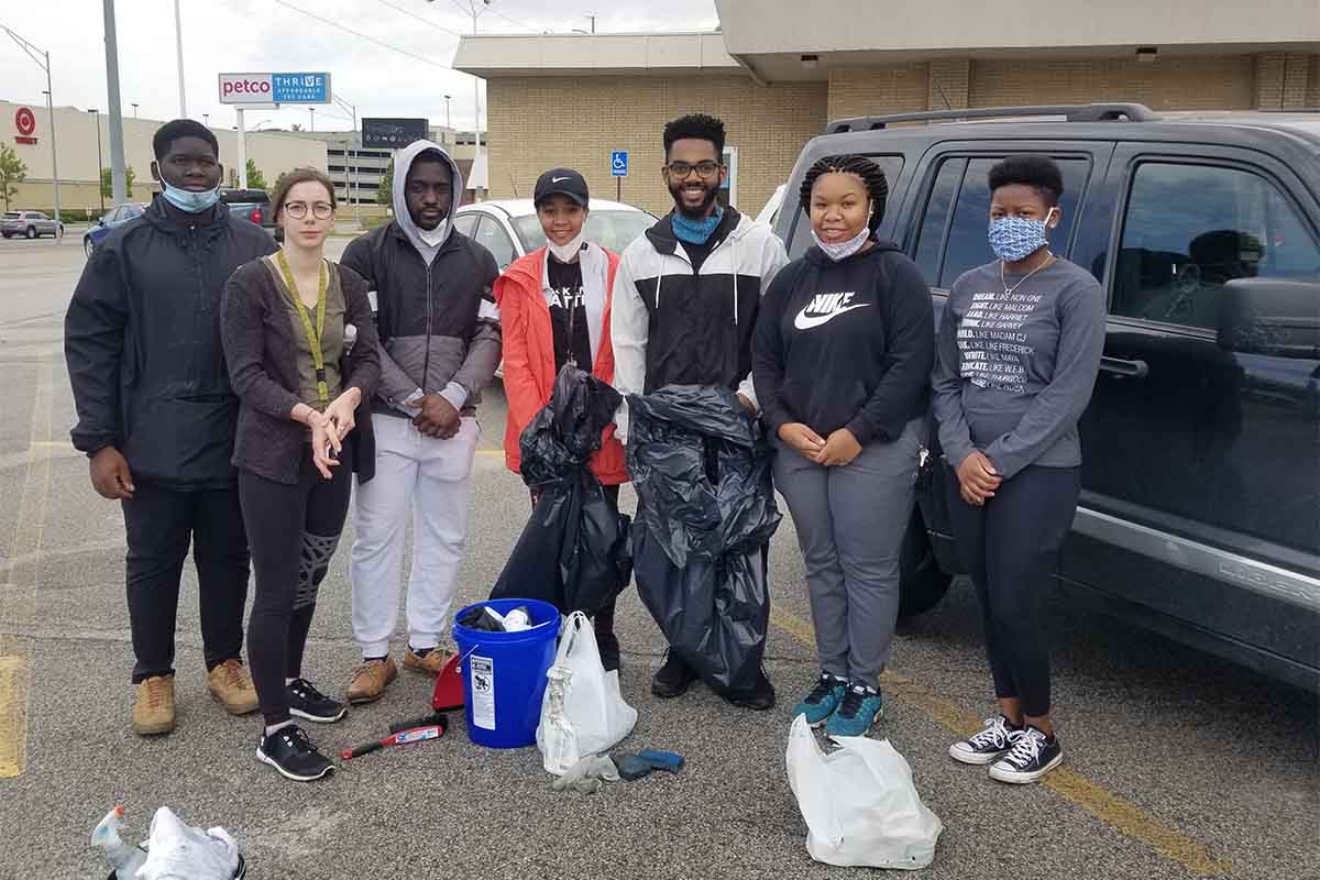 UNO students who helped clean pose for a photo in a parking lot near 72nd and Dodge. From left: Noor Kanunde, Moriah Draper, Tyvon Merritt, Alexandria Mitchel, Jabin Moore, Kaia Phelps, and Kya Bullock.