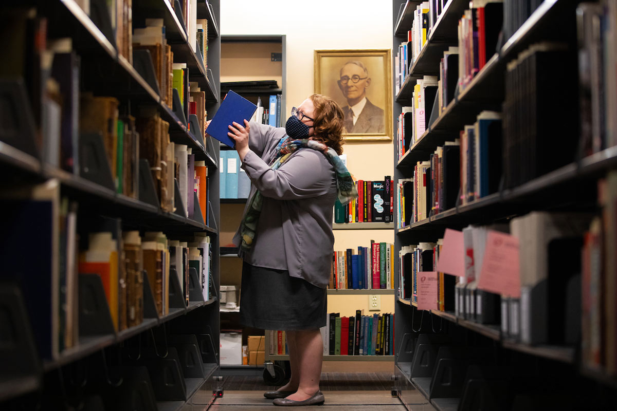 A library employee stocks book shelves