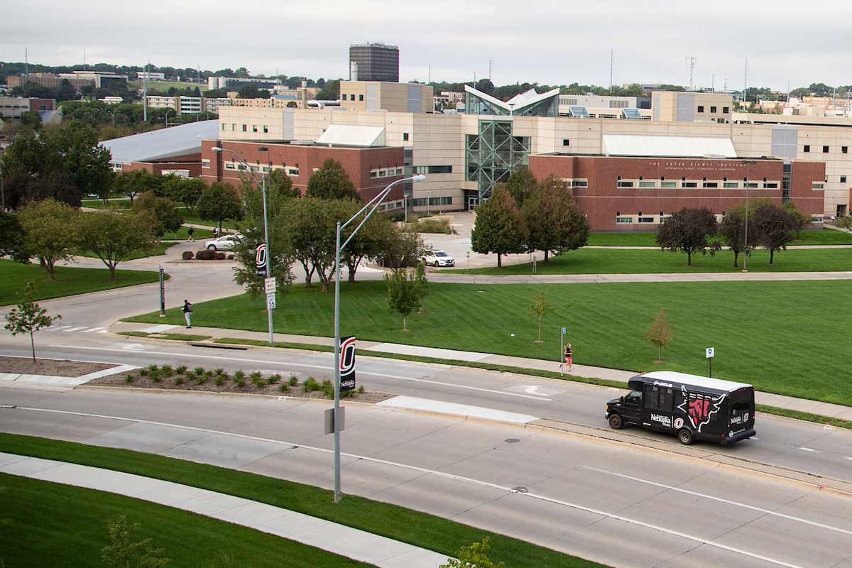 A UNO campus shuttle driving through Scott Campus