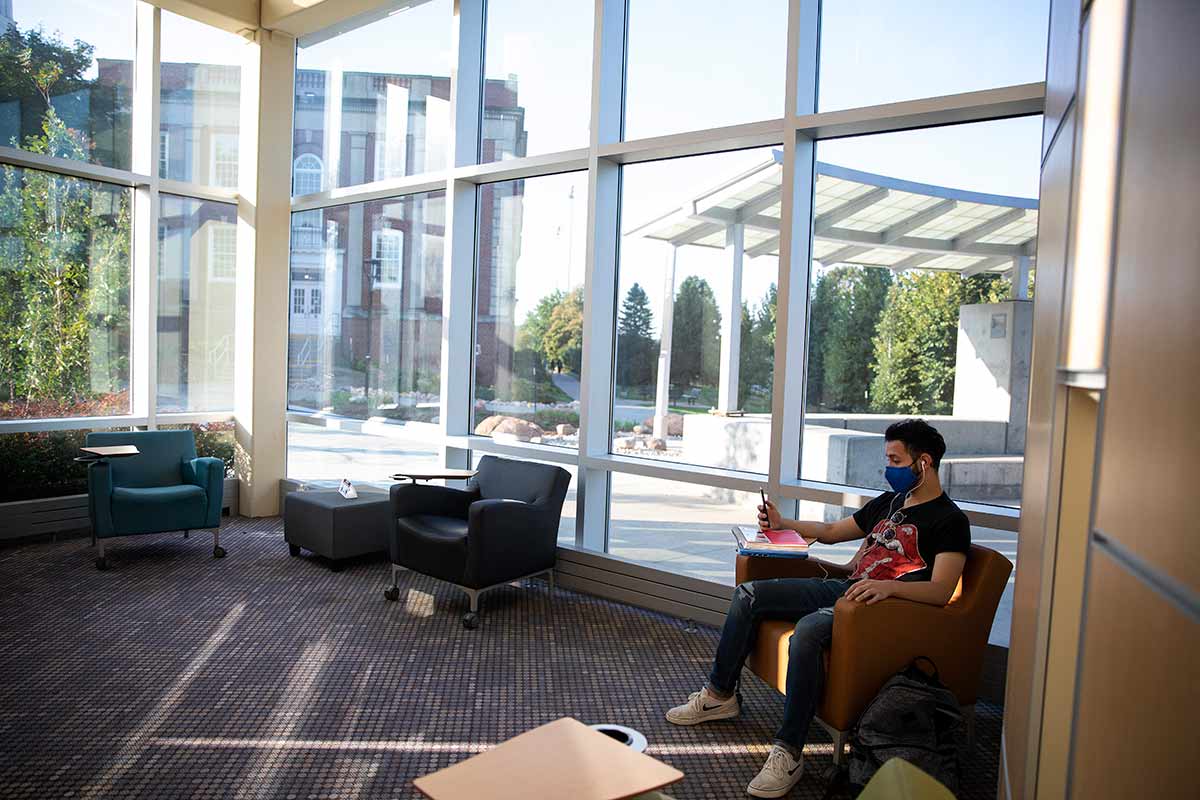 A photo of a student sitting inside the Roskens Hall atrium