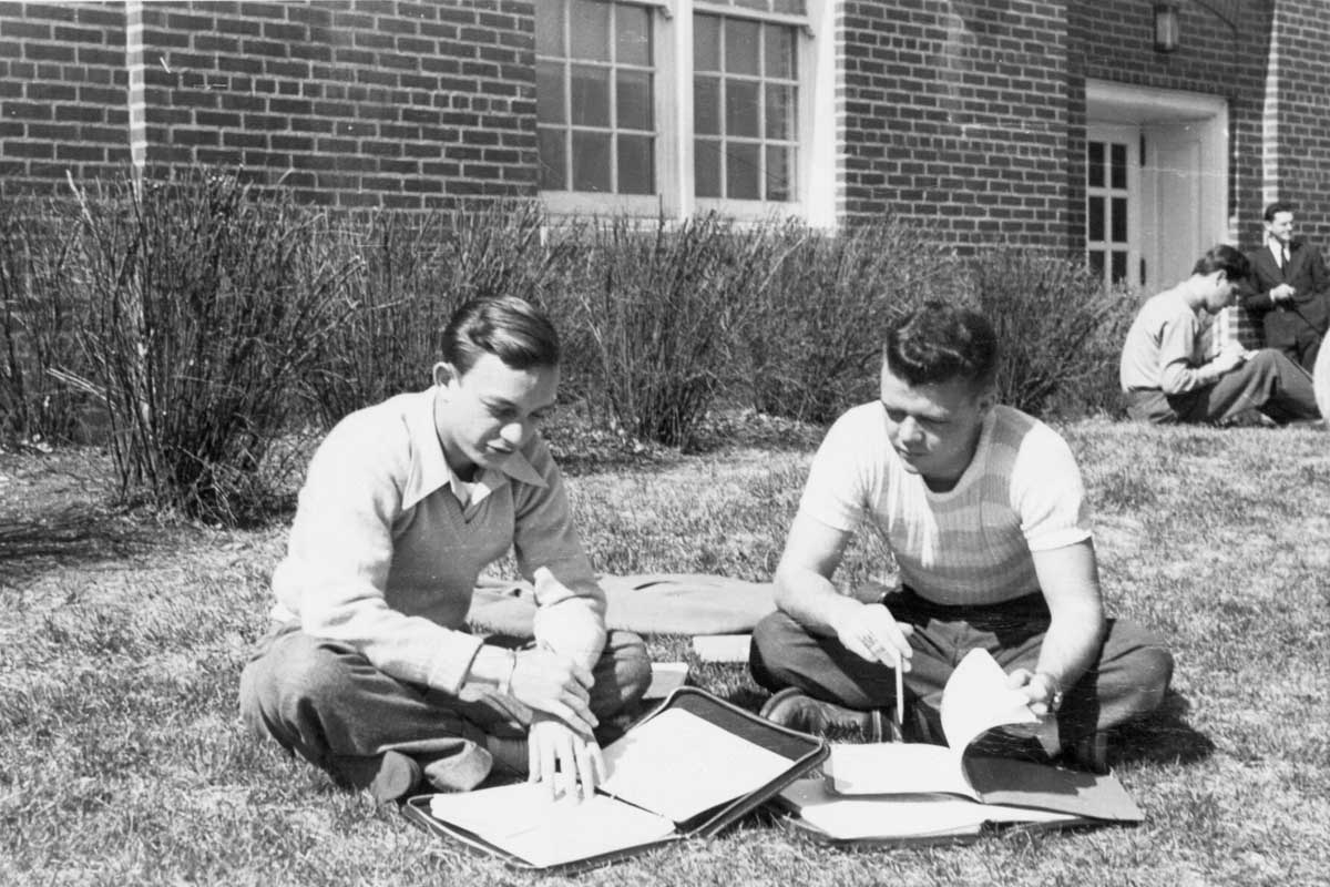 A pair of students study on the grass outside of Arts and Sciences Hall in 1946.