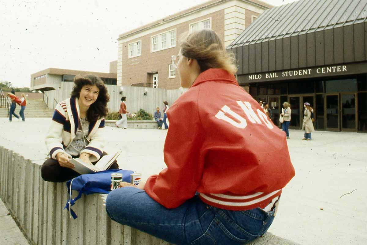 Two students study outside the Milo Bail Student Center in the early 1980s