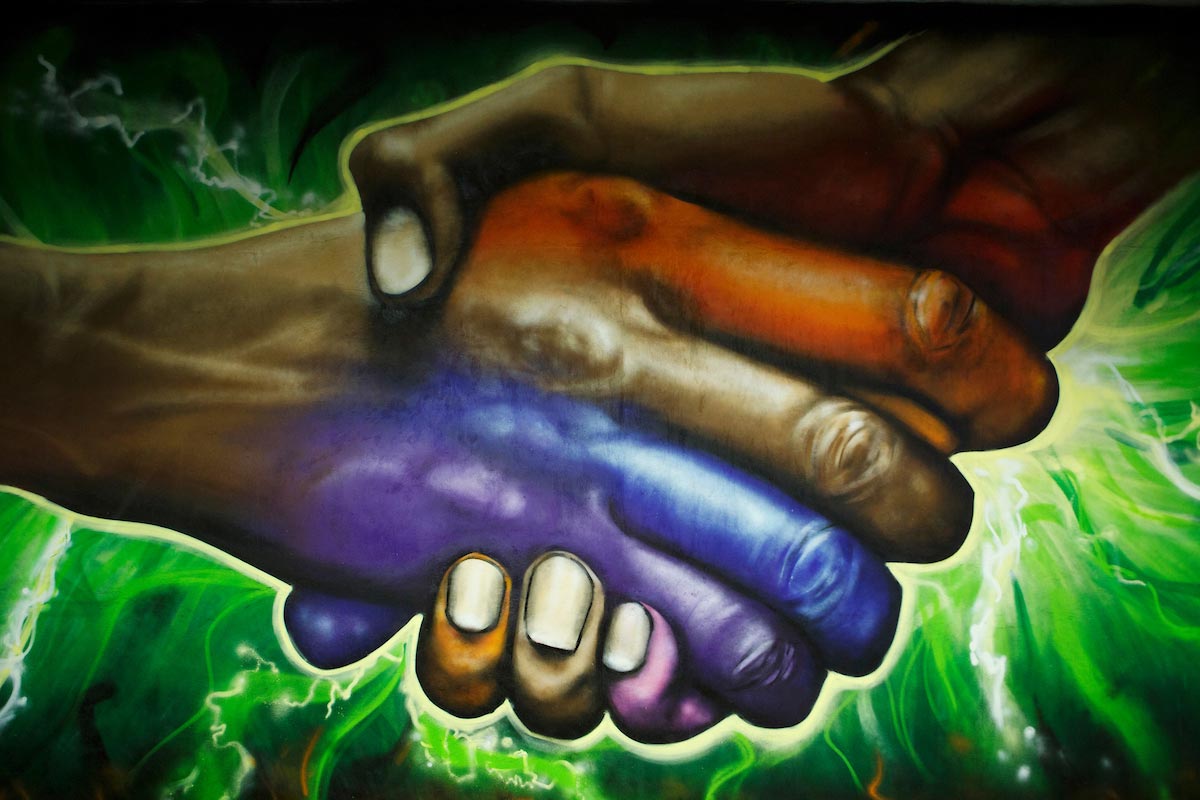 A mural of two hands shaking, located inside the Barbara Weitz Community Engagement Center
