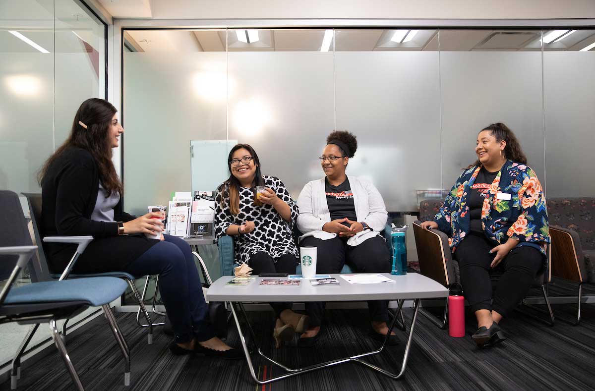 A photo of students seated and talking in the Multicultural Affairs Office