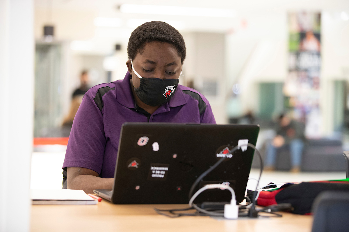 A student checks their laptop in the Milo Bail Student Center