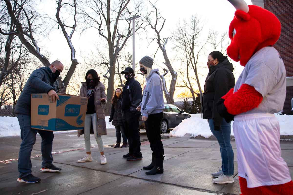 A group of resident assistants gather to begin delivering boxed meal to students.