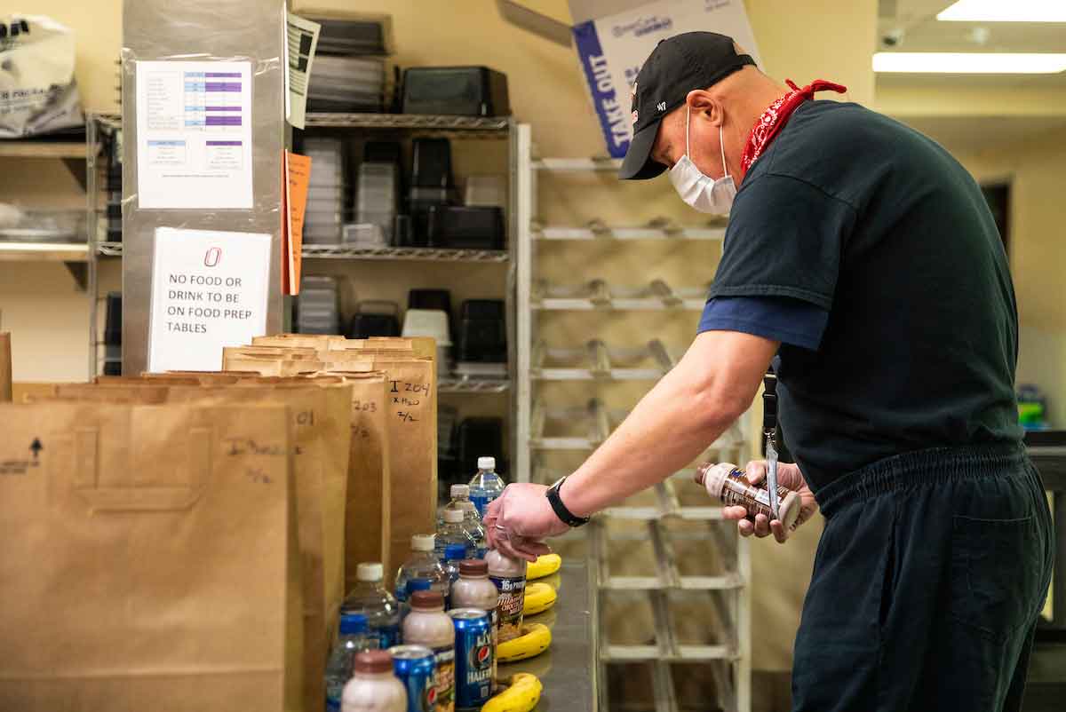 Food Services Manager Louis Gornick prepares bagged meals for students.