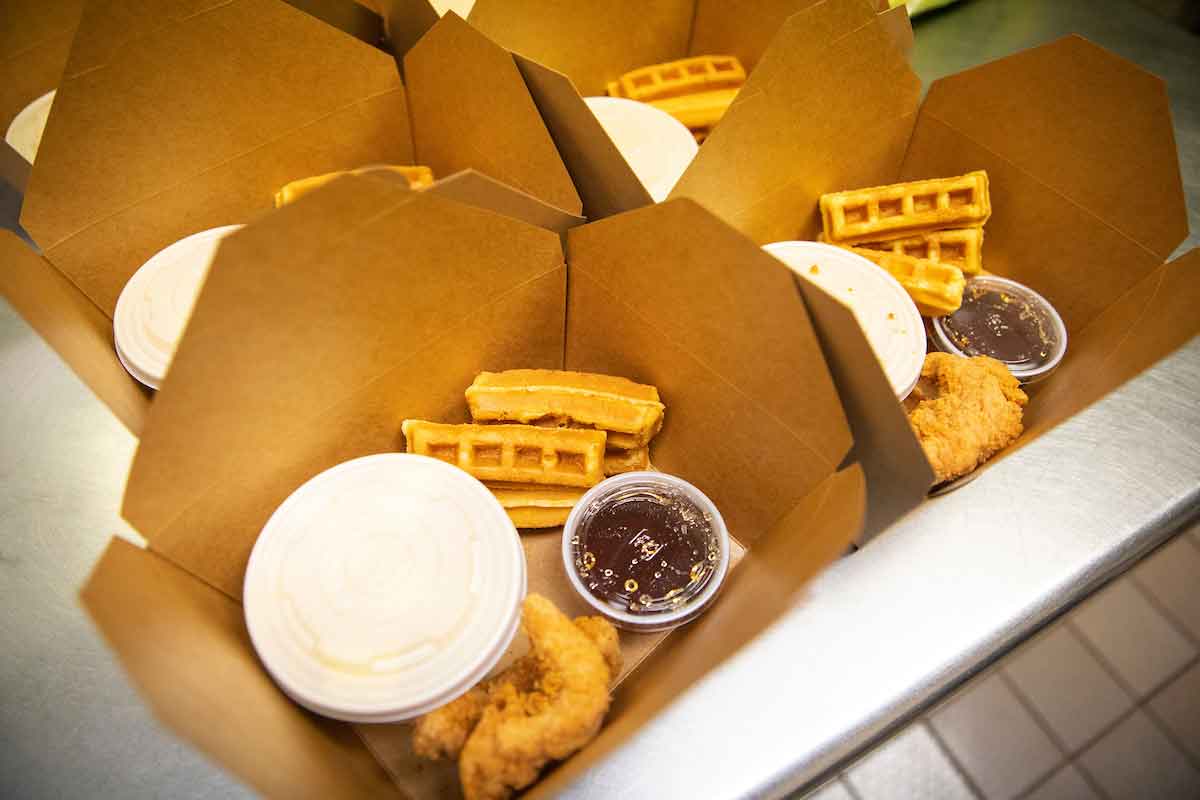 A boxed meal with chicken and waffles.