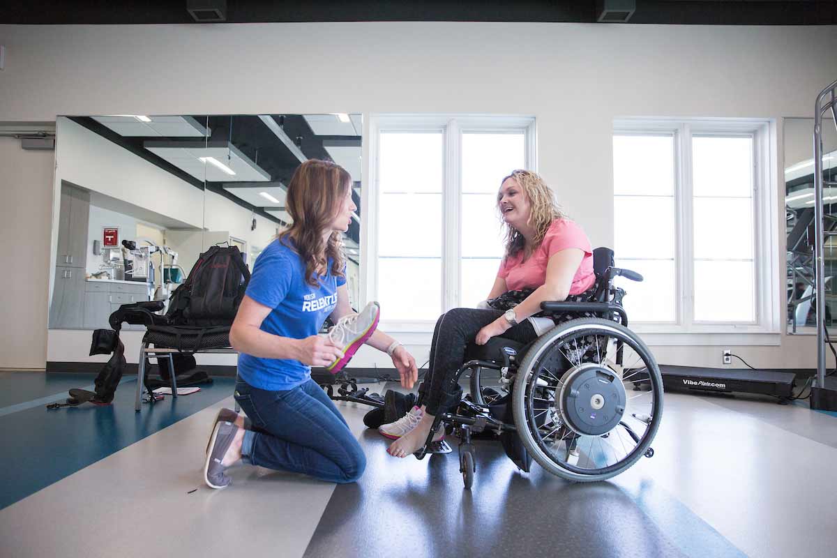 Taryn Schaaf works with a physical therapist at QLI.