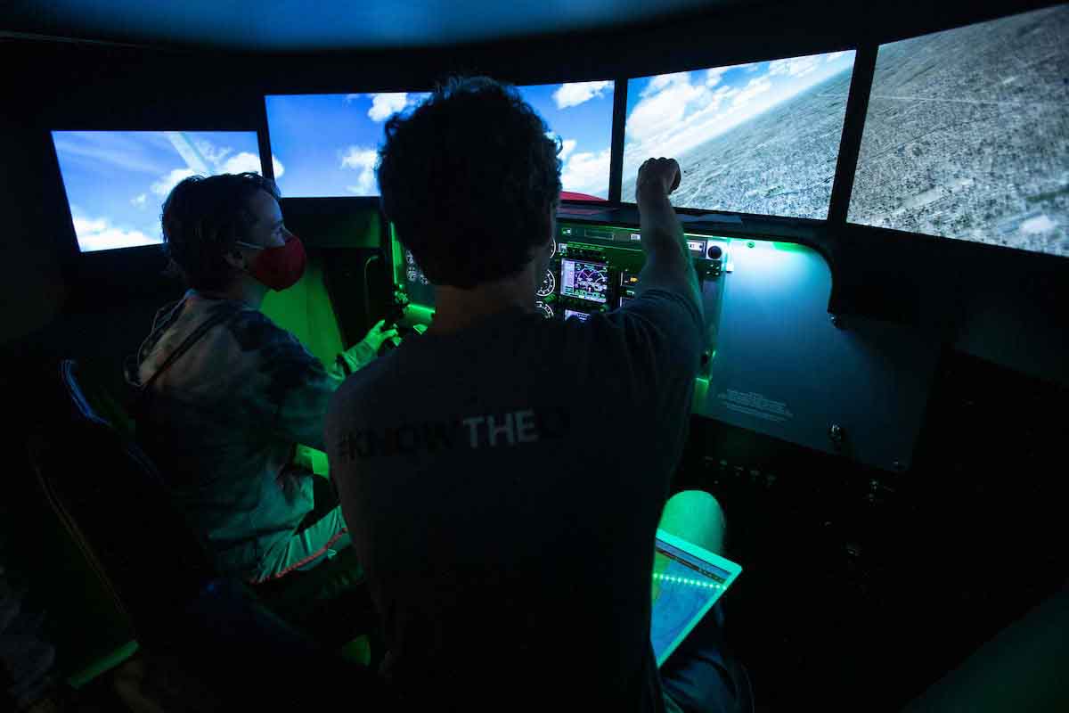 A camper experiences UNO's flight simulator