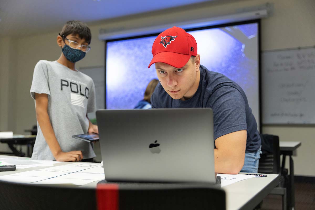 A UNO student helps a Techademy camper