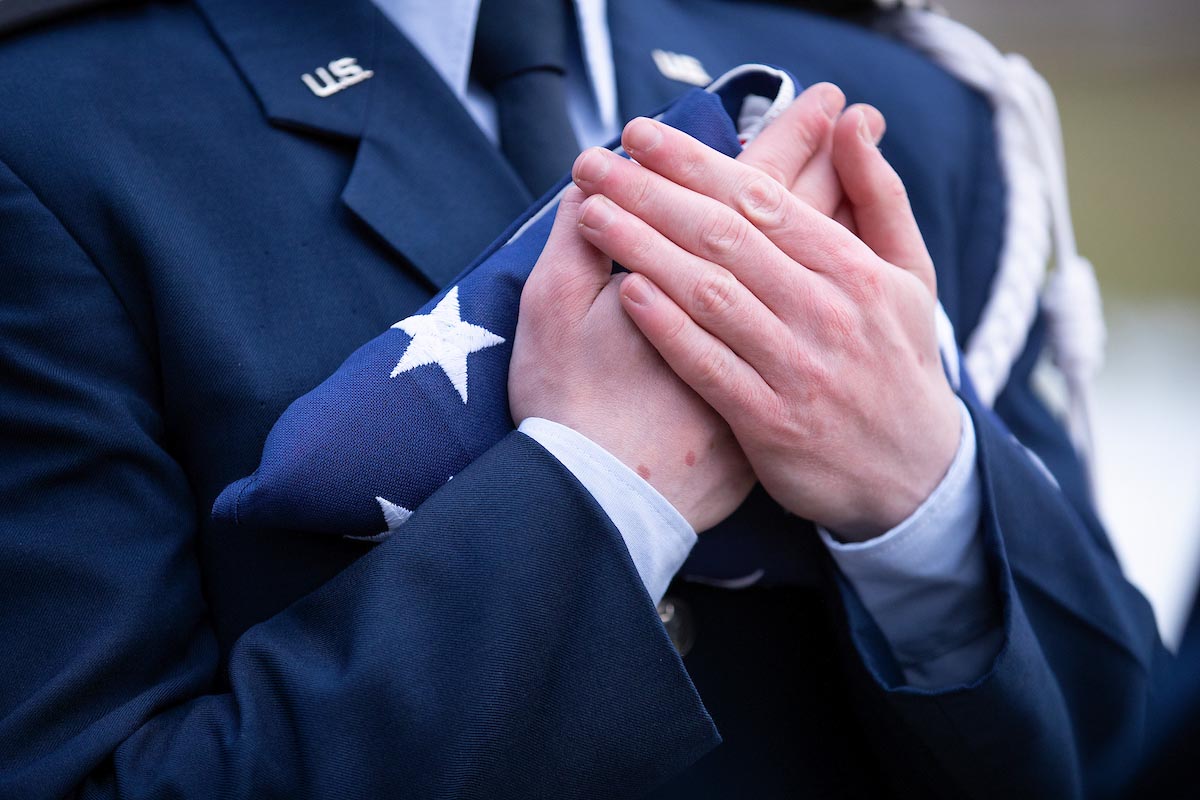 A member of UNO’s AFROTC holds the American flag prior to a flag raising held on campus in early 2021.