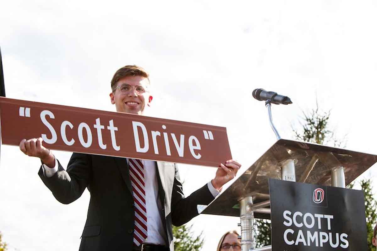 Patrick Davlin holds up a "Scott Drive" sign