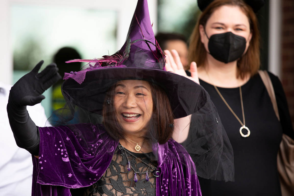 Chancellor Li, in a witch costume, waves to children from the UNO Child Care Center