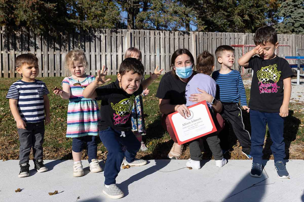 Allison Johnson celebrates her Employee of the Month award with children from the UNO Child Care Center.