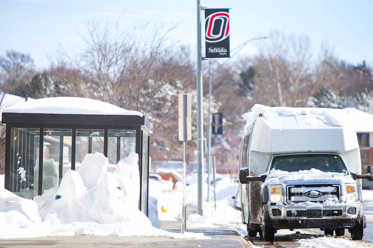 A UNO campus shuttle covered in snow
