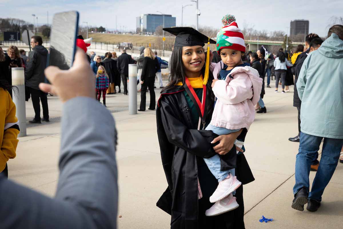 A mom holds her daughter following the morning December 2021 Commencement ceremony.