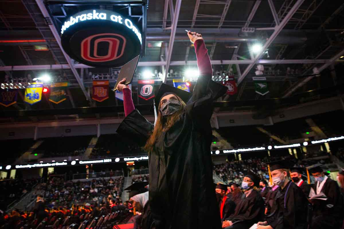 A student celebrates under Baxter Arena's video board