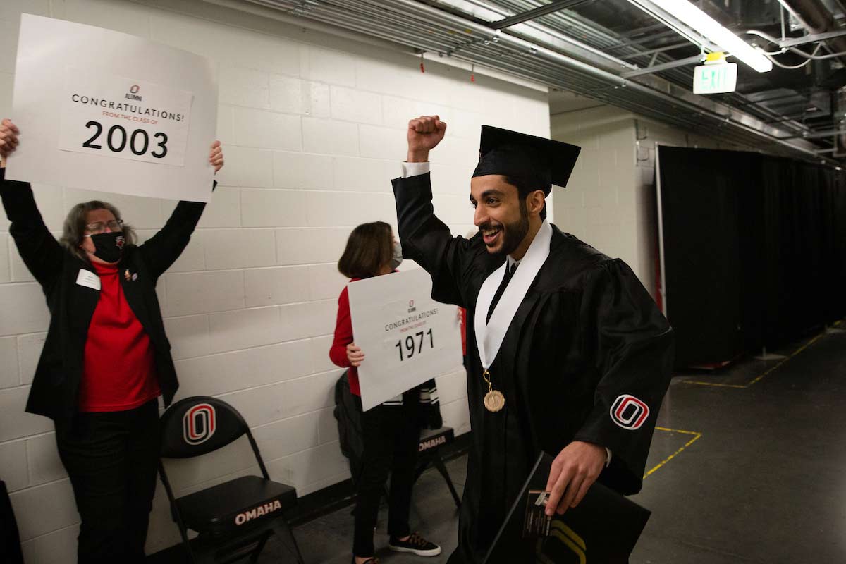A student is cheered on by UNO alumni