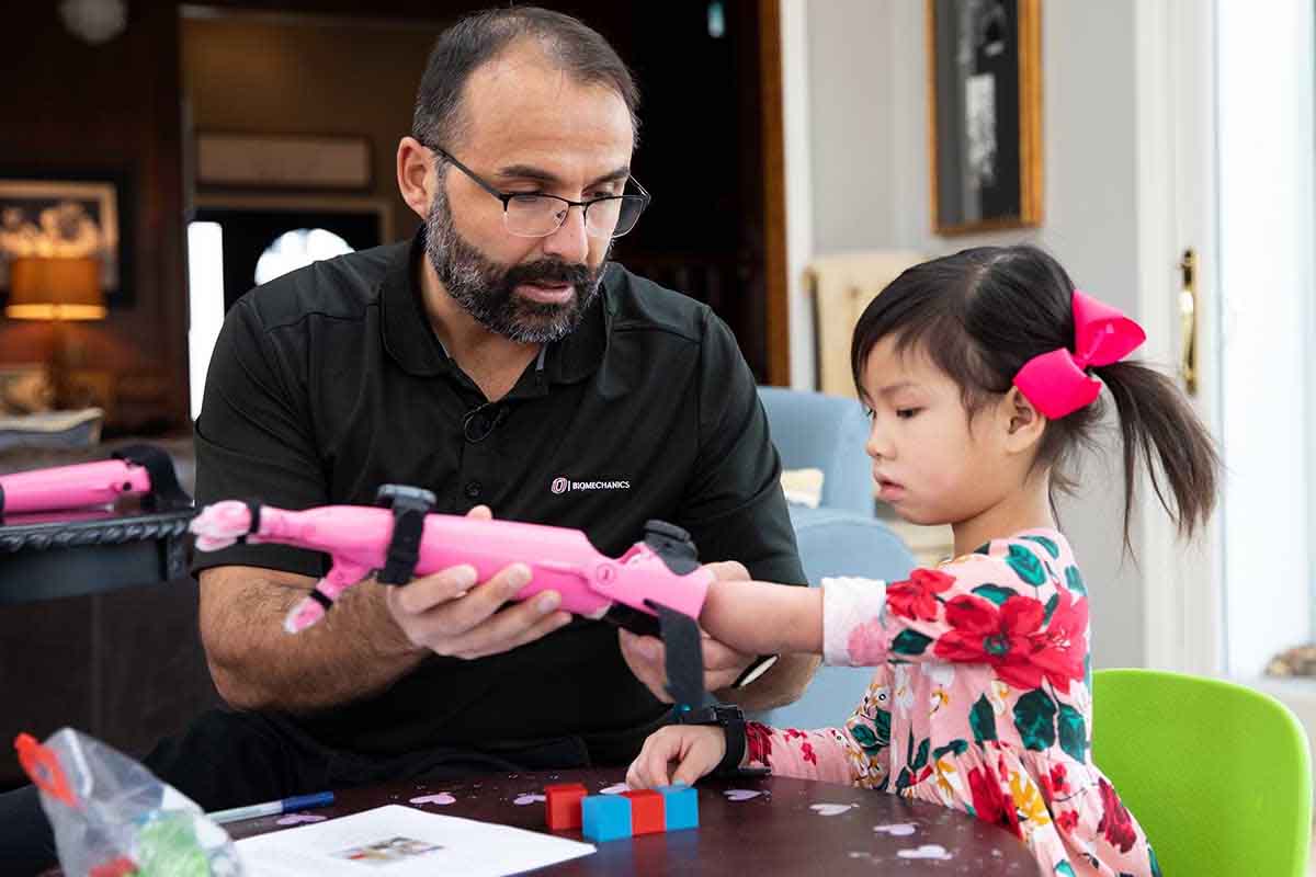 Jorge Zuniga, Ph.D., with young girl using 3D-printed prostheses.