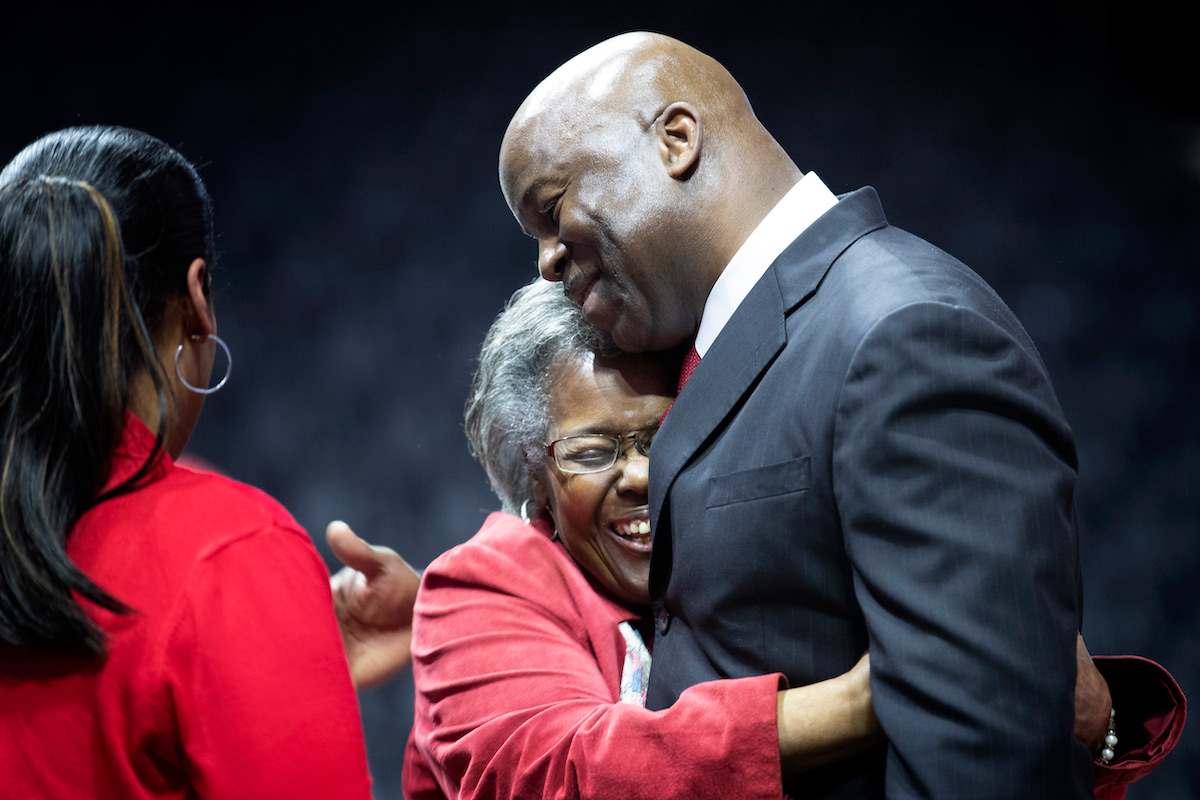 Omaha men's basketball coach Chris Crutchfield embraces loved ones.