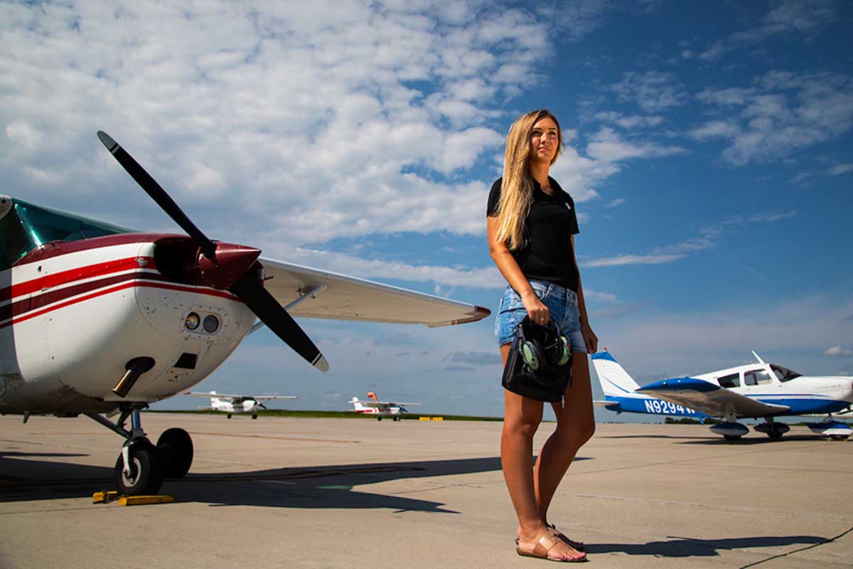 UNO alumna Madchen Pentry stands on a tarmac